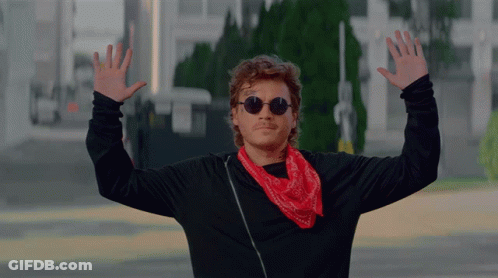 A Man Wearing Sunglasses And A Red Bandana Waves His Hands In The Air GIF
