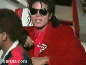 A Man Wearing Sunglasses And A Red Jacket Has A Badge On His Jacket GIF