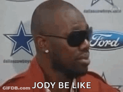 A Man Wearing Sunglasses And A Red Shirt Is Standing In Front Of A Ford Sign . GIF