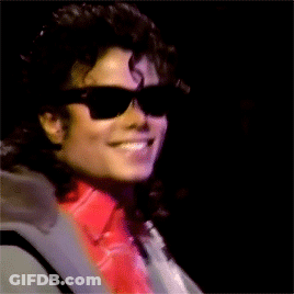 A Man Wearing Sunglasses And A Red Shirt Smiles GIF