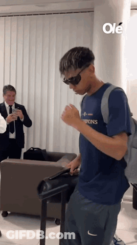 A Man Wearing Sunglasses And A Shirt That Says Champions GIF