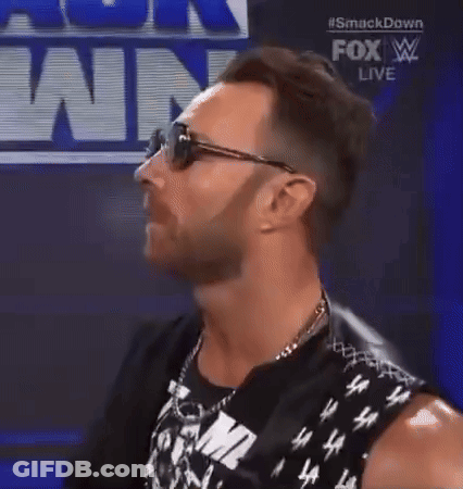 A Man Wearing Sunglasses And A Sleeveless Shirt Is Standing In Front Of A Fox Live Sign . GIF