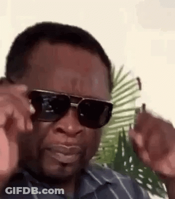 A Man Wearing Sunglasses And A Striped Shirt Is Making A Face . GIF