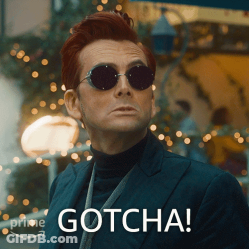 A Man Wearing Sunglasses And A Suit Has Gotcha Written On His Face GIF