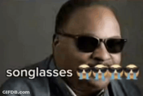 A Man Wearing Sunglasses And A Suit With The Words Songglasses Written On It . GIF