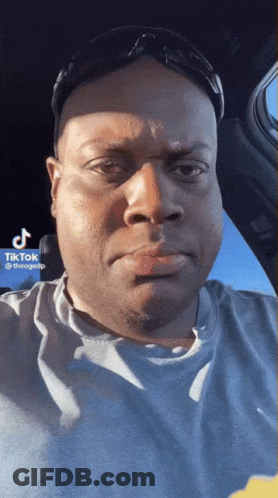 A Man Wearing Sunglasses And A T-Shirt Has A Tiktok Sticker On His Face GIF