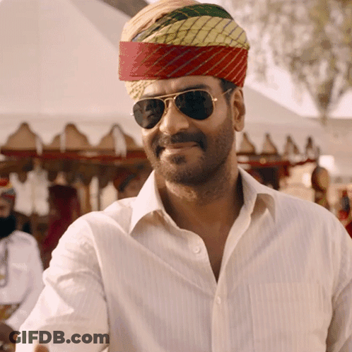 A Man Wearing Sunglasses And A Turban Is Smiling For The Camera GIF