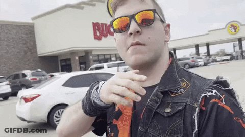 A Man Wearing Sunglasses And A Vest Is Standing In Front Of A Buck 'S Restaurant GIF