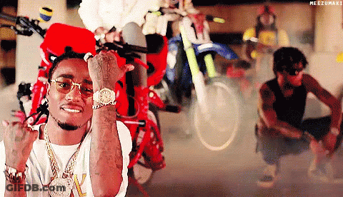 A Man Wearing Sunglasses And A Watch Is Giving The Middle Finger In Front Of Motorcycles . GIF