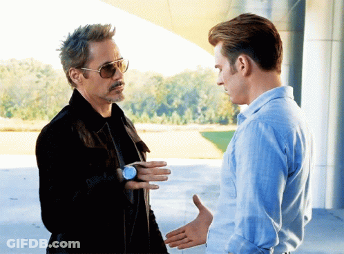 A Man Wearing Sunglasses And A Watch Talks To Another Man GIF