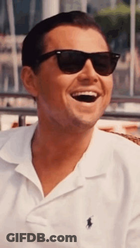 A Man Wearing Sunglasses And A White Polo Shirt Is Laughing . GIF