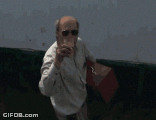 A Man Wearing Sunglasses And A White Shirt Holds A Red Bag GIF