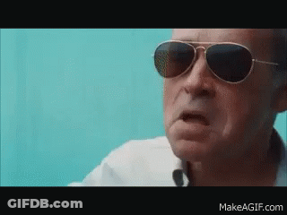 A Man Wearing Sunglasses And A White Shirt Is Making A Funny Face GIF