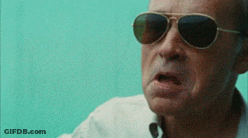 A Man Wearing Sunglasses And A White Shirt Is Making A Funny Face GIF
