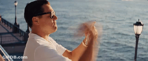 A Man Wearing Sunglasses And A White Shirt Is Sitting On A Boat Looking At The Ocean . GIF