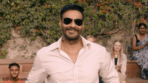 A Man Wearing Sunglasses And A White Shirt Is Smiling GIF