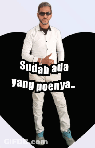 A Man Wearing Sunglasses And A White Shirt Is Standing In Front Of A Heart That Says Sudah Ada Yang Poenya GIF