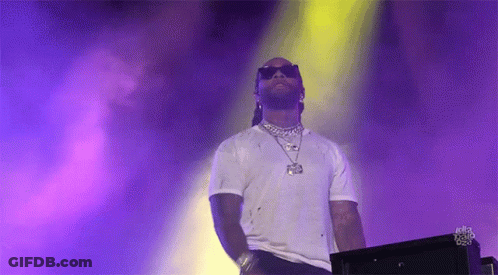 A Man Wearing Sunglasses And A White Shirt Is Standing In Front Of A Purple And Yellow Background . GIF