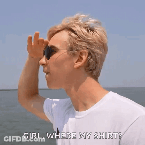 A Man Wearing Sunglasses And A White Shirt Is Standing On A Boat And Looking At The Water . GIF