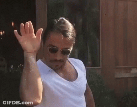 A Man Wearing Sunglasses And A White Shirt Is Waving His Hand In Front Of A Window . GIF