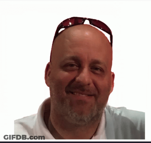 A Man Wearing Sunglasses And A White Shirt Smiles For The Camera GIF