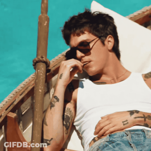 A Man Wearing Sunglasses And A White Tank Top Has A Tattoo On His Arm That Says ' Ii ' GIF