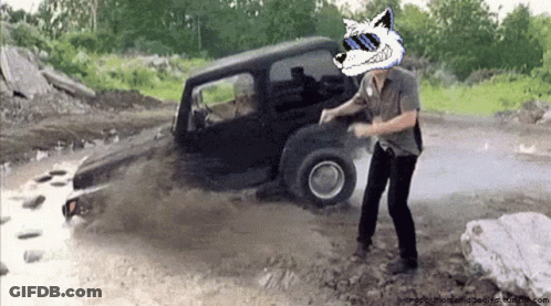 A Man Wearing Sunglasses And A Wolf Head Is Standing In Front Of A Jeep GIF