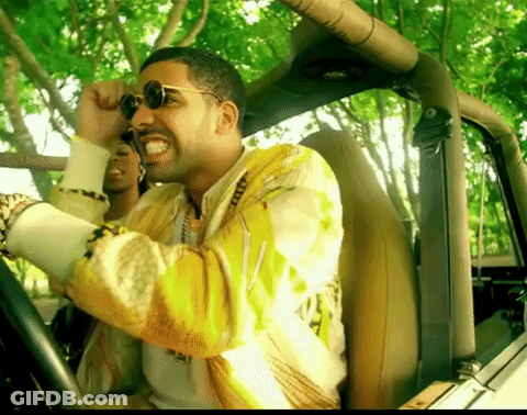 A Man Wearing Sunglasses And A Yellow Jacket Is Driving A Vehicle GIF
