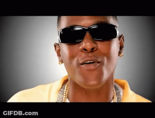 A Man Wearing Sunglasses And A Yellow Shirt Is Making A Funny Face GIF