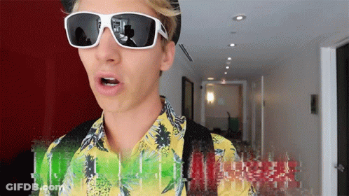 A Man Wearing Sunglasses And A Yellow Shirt With The Word Hawaii On It GIF