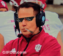 A Man Wearing Sunglasses And Headphones Is Wearing A Red Adidas Jacket GIF