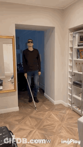 A Man Wearing Sunglasses And Holding A Cane In A Hallway With The Words Iknow Below Him GIF
