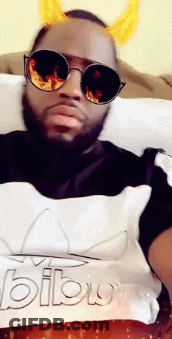 A Man Wearing Sunglasses And Horns Is Laying On A Bed GIF