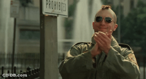 A Man Wearing Sunglasses Applauds In Front Of A Sign That Says Prohibited GIF
