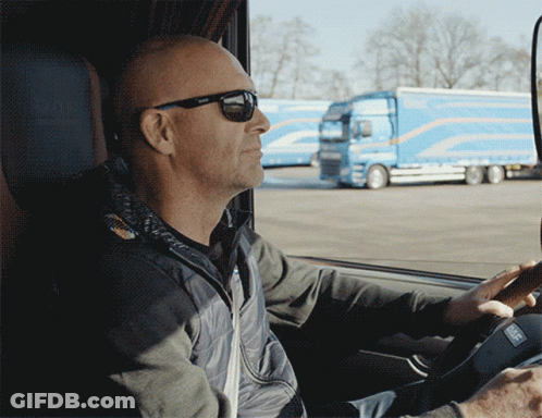 A Man Wearing Sunglasses Is Driving A Car GIF