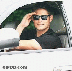 A Man Wearing Sunglasses Is Driving A Car GIF