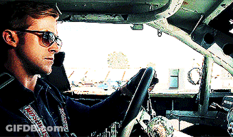 A Man Wearing Sunglasses Is Driving A Car With A Simpson Sticker On His Jacket GIF