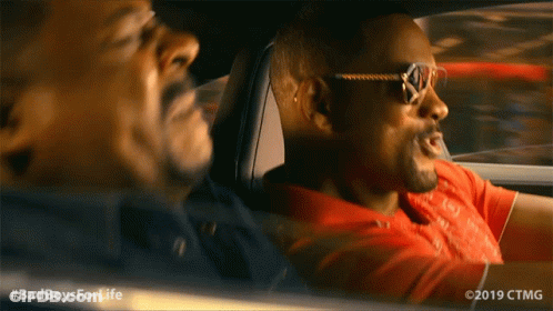 A Man Wearing Sunglasses Is Driving Another Man In A Car With The Hashtag #Badboysforlife GIF