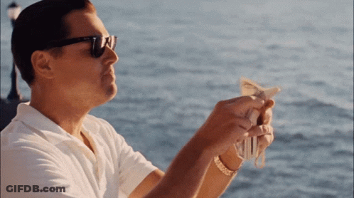 A Man Wearing Sunglasses Is Holding A Bunch Of Money In His Hands GIF