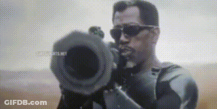 A Man Wearing Sunglasses Is Holding A Camera In His Hand And Pointing It At The Camera . GIF