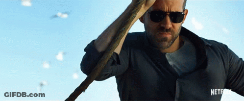 A Man Wearing Sunglasses Is Holding A Cane In Front Of A Blue Sky GIF