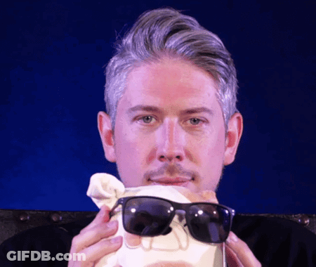 A Man Wearing Sunglasses Is Holding A Skull In His Hands GIF