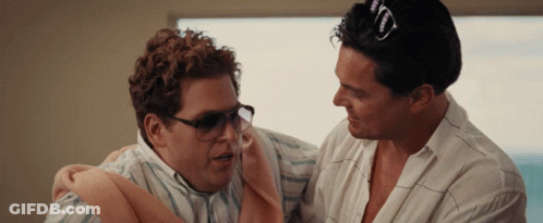 A Man Wearing Sunglasses Is Holding Another Man In His Arms GIF