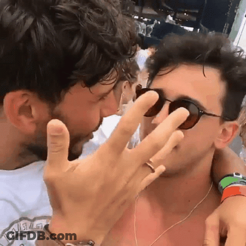 A Man Wearing Sunglasses Is Kissing Another Man 'S Forehead GIF