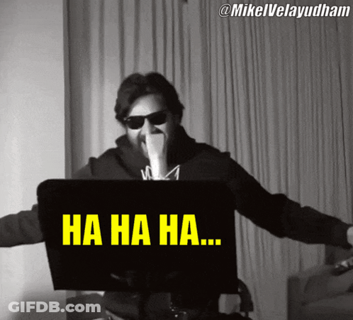 A Man Wearing Sunglasses Is Laughing In Front Of A Laptop Screen That Says Ha Ha Ha GIF