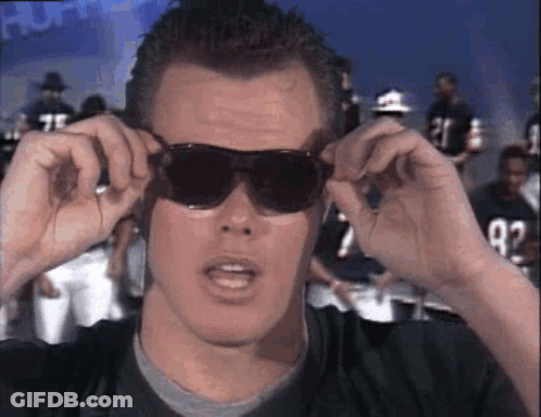 A Man Wearing Sunglasses Is Looking At The Camera . GIF