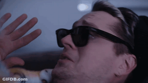 A Man Wearing Sunglasses Is Looking Through A Window GIF