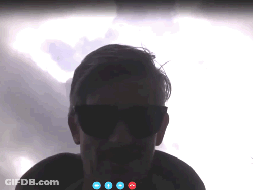 A Man Wearing Sunglasses Is On A Video Call With Three Blue Buttons GIF