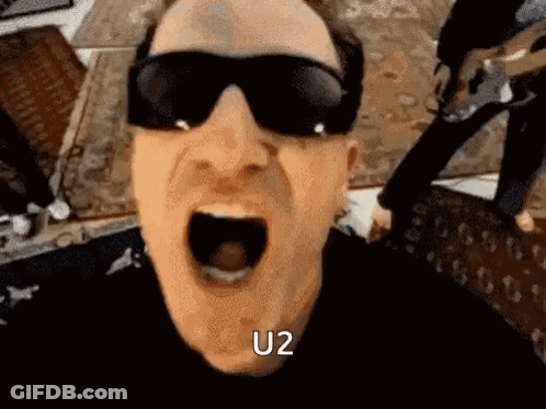 A Man Wearing Sunglasses Is Screaming With His Mouth Open And The Word U2 Written On His Face . GIF