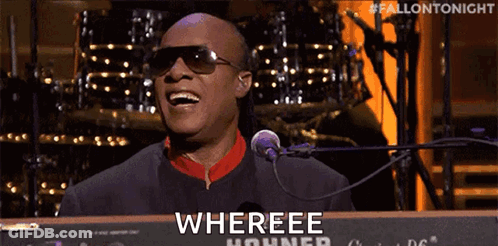 A Man Wearing Sunglasses Is Singing Into A Microphone While Playing A Keyboard That Says Whereee Hohner GIF